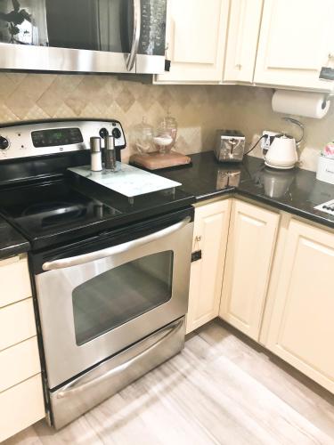 a kitchen with white cabinets and a stainless steel oven at Villa Sierra in Sonora