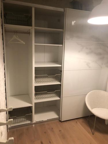 a closet with white cabinets and a table and chair at Lichtrijke loft bij restaurant Den Olifant in Ypres