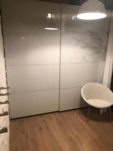 a room with a white closet and a chair at Lichtrijke loft bij restaurant Den Olifant in Ypres