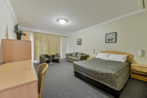 a hotel room with a bed and a couch at Golden Guitar Motor Inn in Tamworth