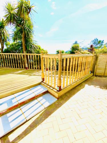 a wooden deck with a fence and palm trees at Villa Mentone Hotel in Shanklin