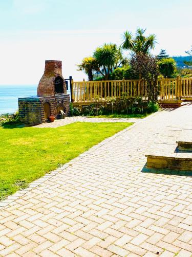 a brick walkway with a wooden fence and a fireplace at Villa Mentone Hotel in Shanklin