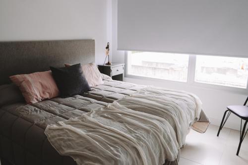 a bedroom with a bed with a blanket on it at Administración MAIPU 3 C DEPTO PREMIUM in Tandil