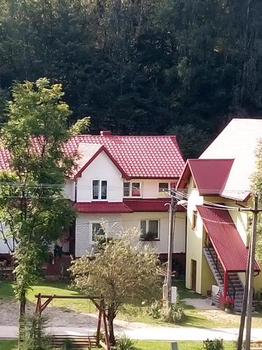 a white house with a red roof at Pokoje gościnne Celina i Waldemar Szwala in Wierchomla Mała