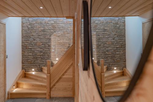 una camera con scale in legno e un muro di mattoni di Chalet "Le Lorgnon" a La Salle-les-Alpes