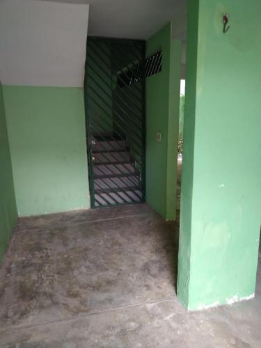 an empty room with green walls and a staircase at Apartamento Espaçoso Renato Maia in Guarulhos