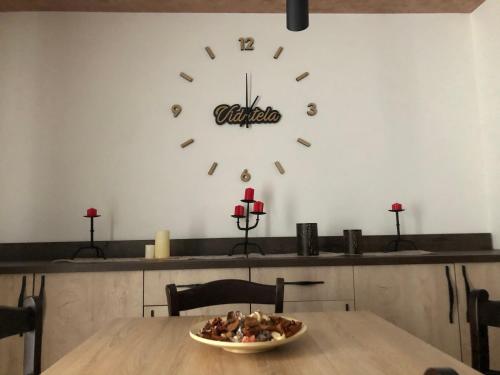 a bowl of food on a table with a clock on the wall at Apartmani Vidatela Kopaonik in Kopaonik