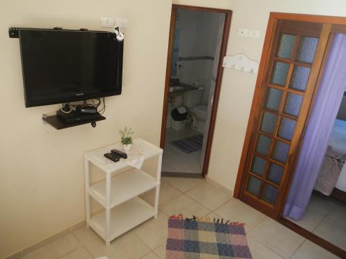 a living room with a flat screen tv on the wall at Recanto da Praia in Paraty