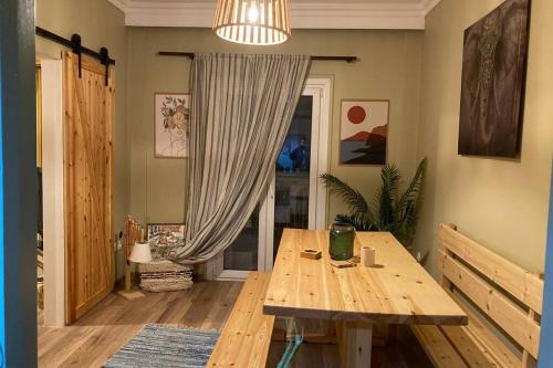 une salle à manger avec une table en bois et une fenêtre dans l'établissement Bohemian Living, à Thessalonique