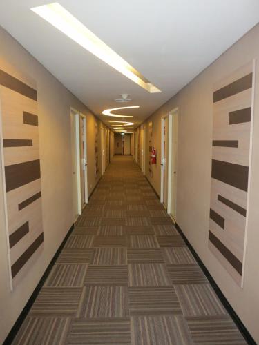 a hallway of an office building with a long corridor at favehotel MEX Tunjungan Surabaya in Surabaya