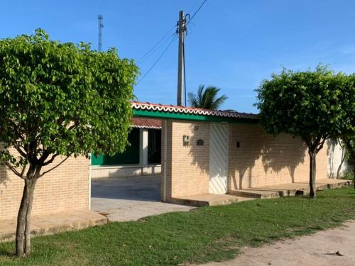 a brick building with trees in front of it at Peróba Praia Azul in Maragogi