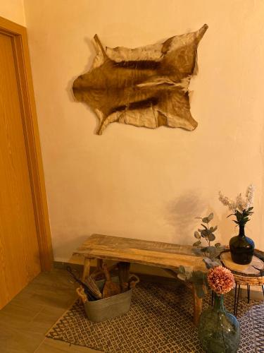 a piece of wood hanging on a wall next to a bench at Finca Las Fuentezuelas in Carataunas