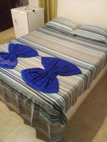 a bed with blue towels on top of it at Pousada Portuguesa in Natal
