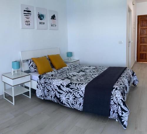 Schlafzimmer mit einem Bett mit einer schwarzen und weißen Bettdecke in der Unterkunft #Ocean view studio #WIFI in Icod de los Vinos