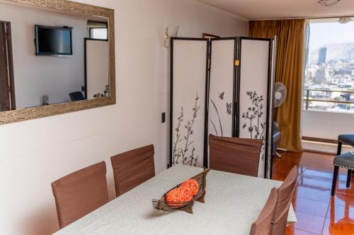 a dining room with a table and a mirror at Departamentos Alpro Cavancha in Iquique