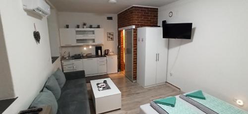 a living room with a couch and a kitchen at Helly's apartman - self check-in - in Jajce