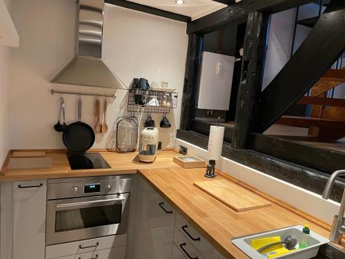 a kitchen with a counter with a stove and a window at Ferienwohnung St. Dionyser Heidedorf in Sankt Dionys