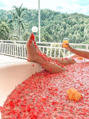 a person laying on a balcony covered in red rose petals at Moondock Luxury Camp in Munduk