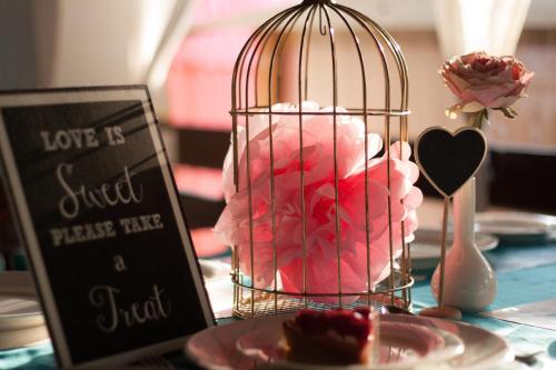 a bird cage filled with pink roses on a table at The Tamarind Hotel - A Boutique Heritage Stay, Anjuna - Goa in Anjuna
