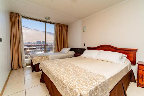 pokój hotelowy z 2 łóżkami i oknem w obiekcie Alpro Urbano Oriente w mieście Iquique