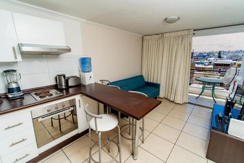 a kitchen with a table and a counter top at Alpro Urbano Oriente in Iquique
