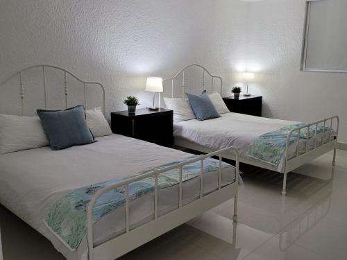 a bedroom with two beds and two lamps on tables at Paradise on Hollywood Beach 2 bed 2 bath in Hollywood