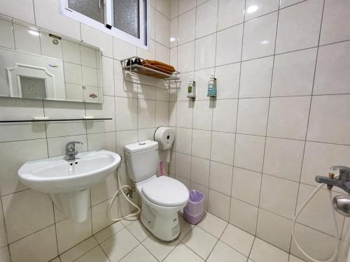 a bathroom with a toilet and a sink at Baisha Bay B&B in Xiaoliuqiu