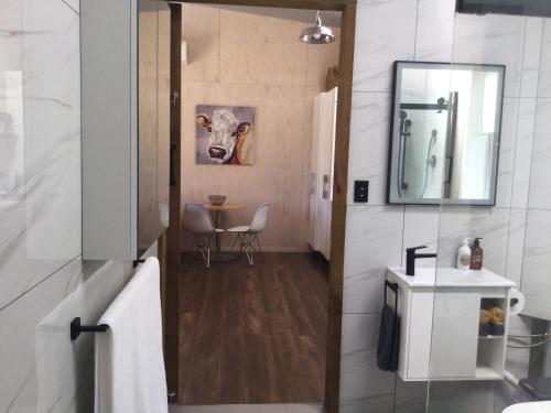 een badkamer met een spiegel en een tafel met stoelen bij Warkworth Barn Retreat in Warkworth