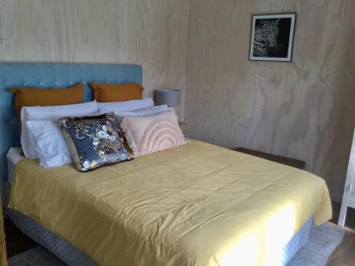 Bett mit blauem Kopfteil und Kissen darauf in der Unterkunft Warkworth Barn Retreat in Warkworth