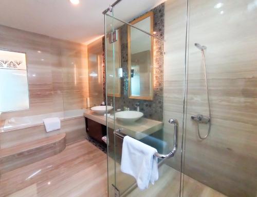 a bathroom with a glass shower and a sink at Swiss-Belhotel Ambon in Ambon