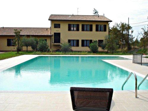 a swimming pool with a chair in front of a house at Ostello Victor Center in Capodacqua