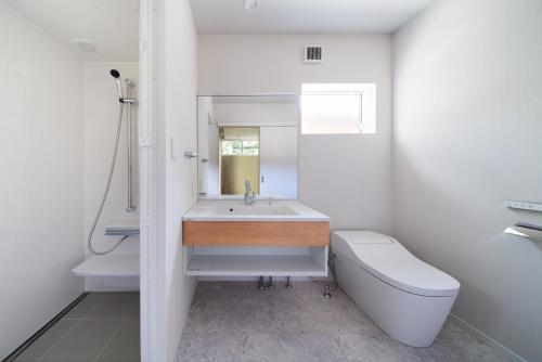 白馬的住宿－Sanzan Chalet by Hakuba White Fox Company，白色的浴室设有水槽和卫生间。