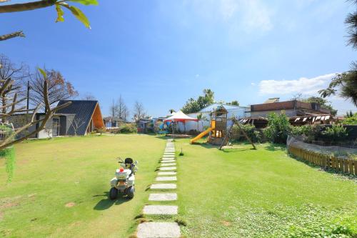 a toy scooter parked in a yard with a pathway at Jiang's B&B 江院子庭園民宿 in Jian