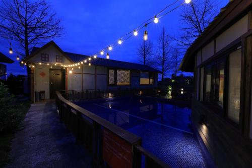 a house with a swimming pool at night with lights at Jiang's B&B 江院子庭園民宿 in Jian