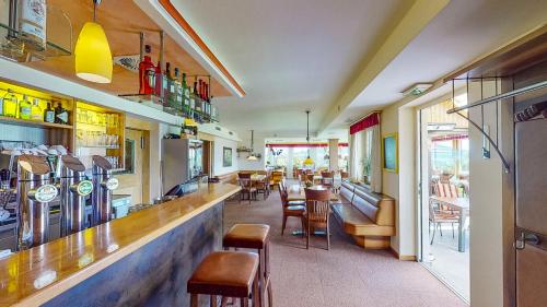 un restaurante con un bar con mesas y sillas en Hotel Haberl - Attersee, en Attersee am Attersee