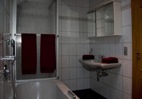 y baño con bañera y lavamanos. en Ferienhaus Ginsterblüte, en Schleiden