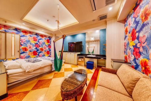 uma sala de estar com uma cama e um sofá em Hotel Atlantis Hawaiian Resorts(Adult only) em Saitama