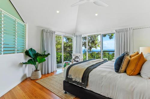 a bedroom with a bed and a large window at Naturally majestic, Noosa Heads in Noosa Heads