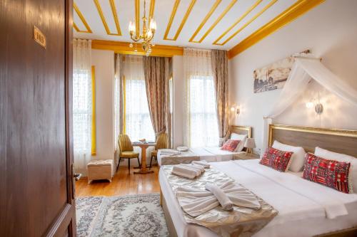 ein Hotelzimmer mit 2 Betten und einem Tisch in der Unterkunft April Hotel in Istanbul