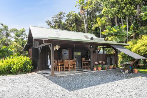 a small cabin with a table and chairs at Daintree Holiday Homes - La Vista in Cow Bay