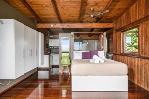 a bedroom with a bed and a kitchen at Daintree Holiday Homes - La Vista in Cow Bay