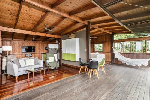an open living room with a couch and chairs at Daintree Holiday Homes - La Vista in Cow Bay