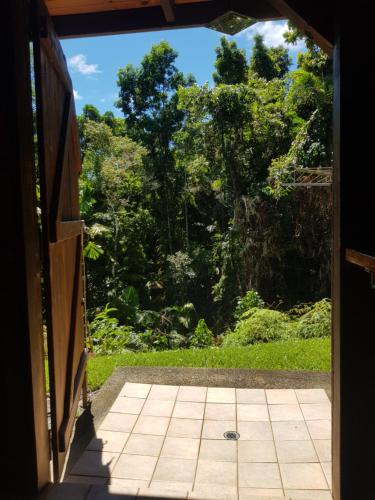an open door to a garden with trees in the background at Daintree Holiday Homes - La Vista in Cow Bay