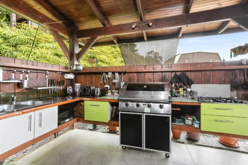 an outdoor kitchen with a stove and a counter top at Daintree Holiday Homes - La Vista in Cow Bay