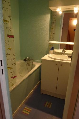 uma casa de banho com um lavatório, um WC, uma banheira e um espelho. em Larnica em Le Corbier
