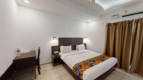 a bedroom with a bed and a desk in a room at De Alcazar Calangute in Calangute
