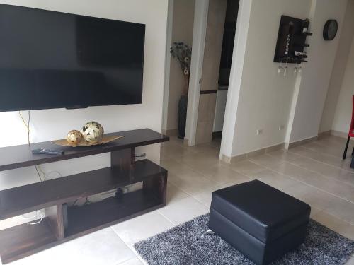 a living room with a large flat screen tv at Elegante apartamento discreto, con playa y piscina in Bique