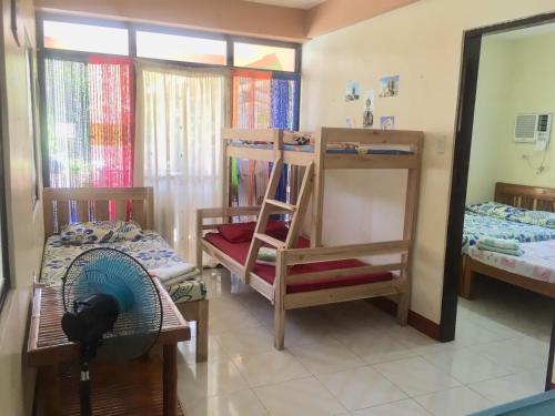 a room with two bunk beds and a mirror at Larosa Hostel Bed and Breakfast in Puerto Princesa City