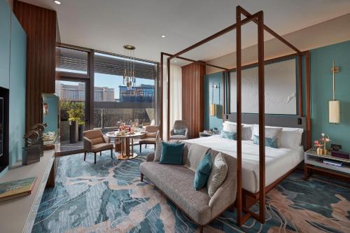 1 dormitorio con cama con dosel y sala de estar. en Mandarin Oriental Wangfujing, Beijing, en Beijing