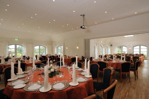 a banquet hall with tables and chairs in a room at Hotel Søparken in Åbybro